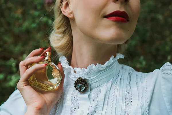 Menina segurando uma garrafa de perfume — Fotografia de Stock