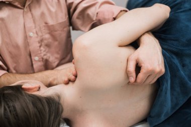 Erkek masör bir kıza masaj yapar, osteopati.