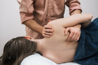 Erkek masör bir kıza masaj yapar, osteopati.