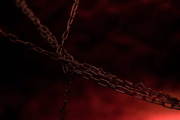 metal chains hang on a black-red background, bdsm accessories