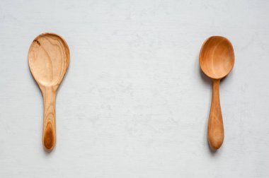 İki ahşap el yapımı kaşık gri bir arka plan üzerinde yalan.