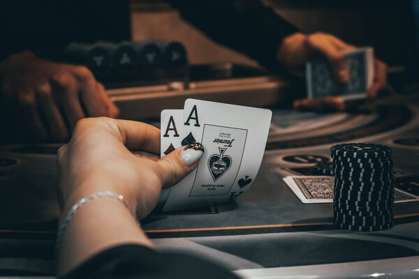 Дилер или крупье перетасовывает покерные карты в казино на фоне стола, фишки,. Концепция игры в покер, игровой бизнес
.