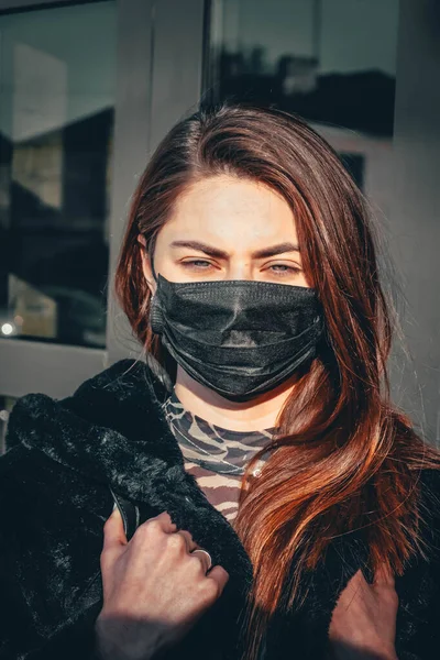 Kız, yüzünde koruyucu steril tıbbi maske takan genç bir kadın Asya sokak gösterilerinde, avuçlarında, ellerinde kameralara bakıyor. Hava kirliliği, virüs, Çin salgını koronavirüs konsepti.