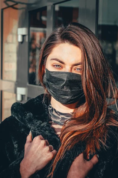 Kız, yüzünde koruyucu steril tıbbi maske takan genç bir kadın Asya sokak gösterilerinde, avuçlarında, ellerinde kameralara bakıyor. Hava kirliliği, virüs, Çin salgını koronavirüs konsepti.