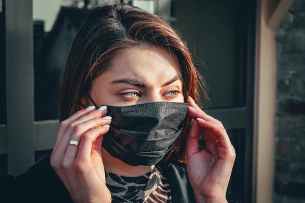 Kız, yüzünde koruyucu steril tıbbi maske takan genç bir kadın Asya sokak gösterilerinde, avuçlarında, ellerinde kameralara bakıyor. Hava kirliliği, virüs, Çin salgını koronavirüs konsepti.