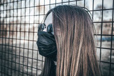 Esmer bir kız sokakta tıbbi bir maskeyle yürüyor, enfeksiyondan korkuyor..