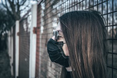 Esmer bir kız sokakta tıbbi bir maskeyle yürüyor, enfeksiyondan korkuyor..