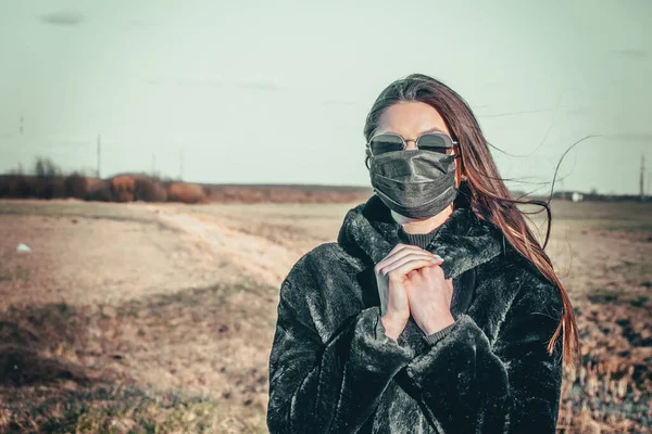 Esmer bir kız sokakta tıbbi bir maskeyle yürüyor, enfeksiyondan korkuyor..