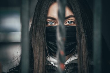 Mavi gözlü, uzun saçlı, tıbbi maske takan seksi bir kadın portresi. Virüslere ve enfeksiyonlara karşı maskeli bir kız. Coronavirus 2019-ncov covid-19 konsepti.