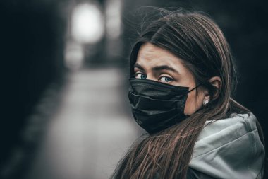 Mavi gözlü, uzun saçlı, tıbbi maske takan seksi bir kadın portresi. Virüslere ve enfeksiyonlara karşı maskeli bir kız. Coronavirus 2019-ncov covid-19 konsepti.