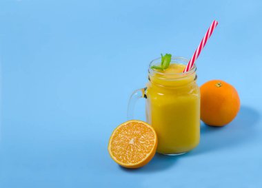 Sarı yüzlü mason kavanoza cam nane ve turuncu ile. Mavi Tablo görünümünün üzerinde. Sağlıklı gıda. Mavi Tablo görünümünün üst. 