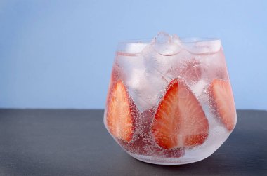 çilek mavi arka plan üzerinde köpüklü su. Bir bardak su çilek yaz. Beyaz ve mavi ahşap arka plan üzerinde soğuk meyve içecekler. Dinlenme içecekler kavramı. Bütün Çilekli kokteyl - gazoz sular 