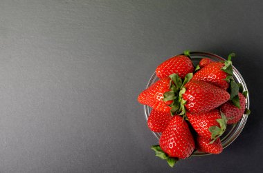 siyah arka plan üzerine çilek. Çilek kopya alanı ile koyu kara tahta üzerinde. Olgun çilek kopya alanı siyah zemin üzerine yığını. Üstten Görünüm noktası.