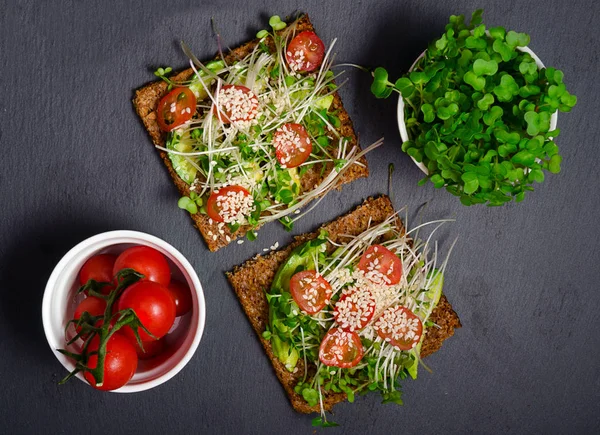 Avocado toast. Sandwich with brown bread. healthy sandwich. Healthy food. Healthy toast. Vegan sandwich. sandwich with avocado, cress salad and tomatoes.