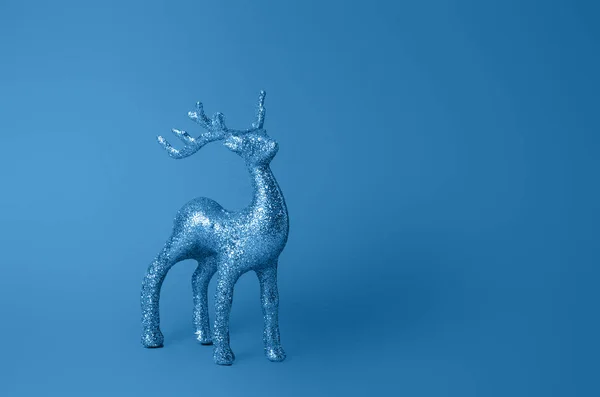 Décoration de cerf étincelant pour Noël. Figurine de cerf isolée sur fond bleu. Le symbole de Noël. Décorations cerf. Décoration cerf pailleté argenté. Couleur de l'année 2020 bleu classique . — Photo