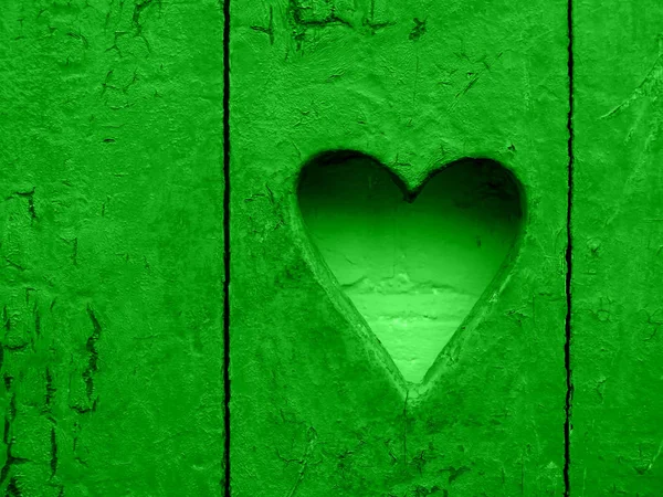 Серце на дерев'яній сільській стіні. Знак серця, діра. справжній зелений колір — стокове фото