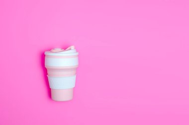 Pembe arka planda beyaz ve pembe yeniden kullanılabilir eko kahve fincanları. Tek kullanımlık plastiği yasakla. Sürdürülebilir yaşam tarzı. Sıfır atık. Çevre bilinci.