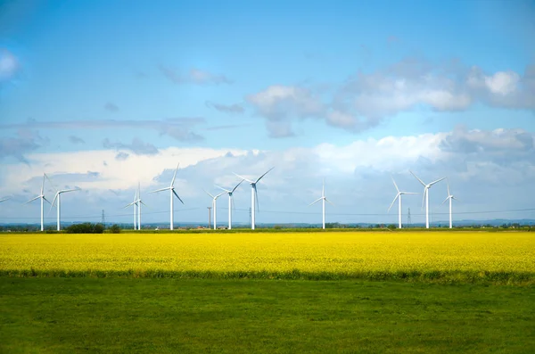 Windmills for electric power - Energy Production with clean and Renewable Energy with green field. Landscape with windmills. English countryside, Britain. Eco energy concept.