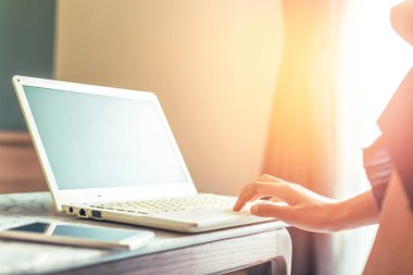 Kadın telefonu ve laptop odasında çalışan kontrol edin. belgili tanımlık laptop tablodur.