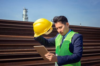 Mühendis, öğle ve sıcak havalarda endüstride test ve kontrol için tablet kullanır. Çalışma konsepti.