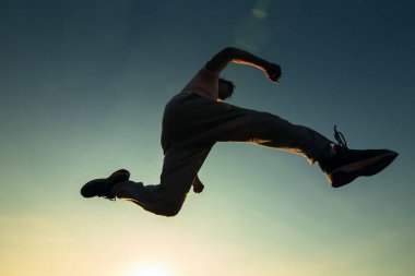 Bir adam koşuyor ve havada zıplıyor..