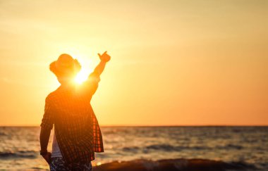 Siluet adam el gün batımında gökyüzünde işaret. Seyahat plaj arka plan.