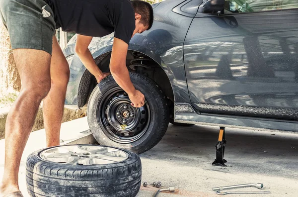 Change a flat car tire at car park with Tire maintenance, damaged car tyre