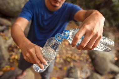 Eller su şişesi tutun ve su dökün.