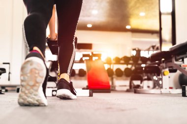 Bir kadın spor ayakkabı giyer.
