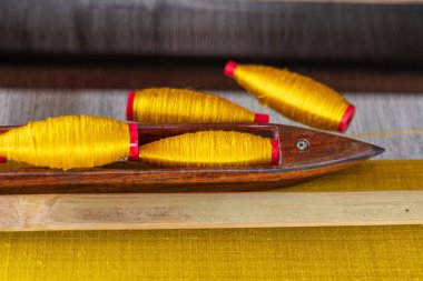 El yapımı ahşap dokuma tezgahında ipek pamuk ören mekik..