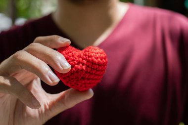 Kalp şeklinde iplik ellerinde. Tatil hediyesi, sevgililer günü konsepti..