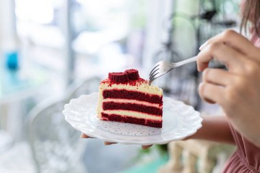 Kırmızı kadife peynirli pasta yemek için el ele tutuşan çatal.