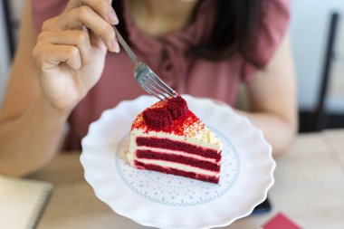 Kırmızı kadife peynirli pasta yemek için el ele tutuşan çatal.