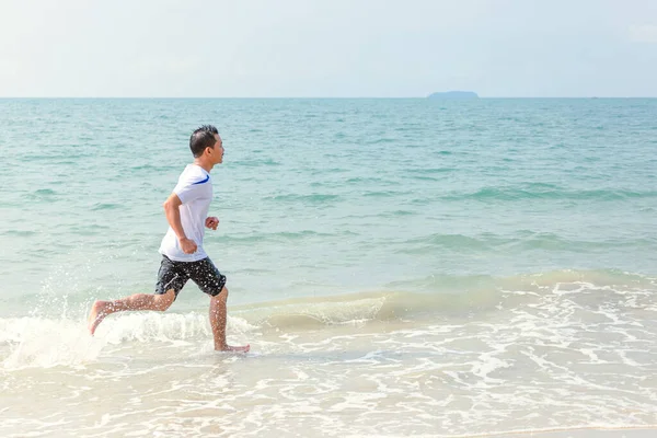 一个男人在海滩上奔跑 — 图库照片