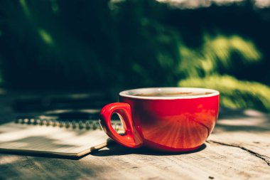 Kahve fincanı kâğıt parçasının yanındaki masada..