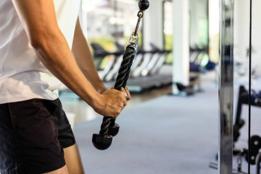 Spor salonunda trisepsi çalıştıran bir adam.