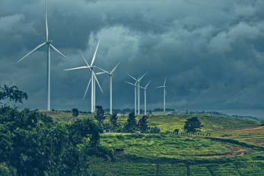 Dağda rüzgar türbini ve yağmur bulutu.