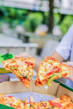 Ofisteki insanlar masadaki pizza dilimlerini alıp paylaşıyorlar. Çalışan ekip çalışanları birlikte yemek yiyor. Tatilin tadını çıkarıyorlar. Teslimat hizmeti konsepti..