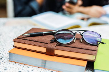 Kitapta gözlük ve kalem var..