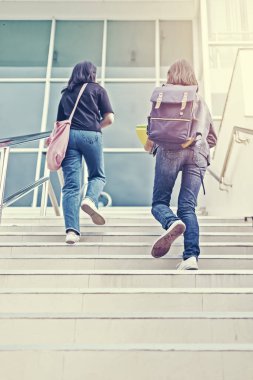 Üniversite öğrencisi merdivenlerden çıkıyor.