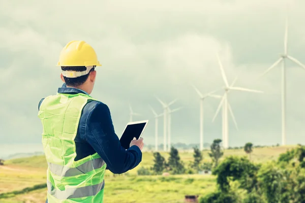 Construction Worker Planning Contractor Checking  at wind turbine construction. A man hold tablet for working.