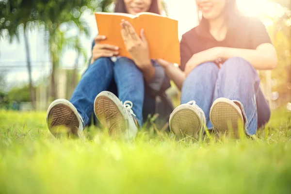 Üniversite Öğrencileri Çimlerin Üzerinde Oturup Kitap Okuyorlar — Stok fotoğraf