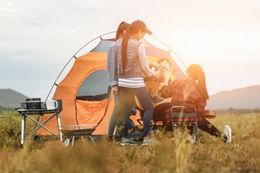 Bir grup arkadaş göl kenarındaki kampta eğleniyor ve içiyorlar..