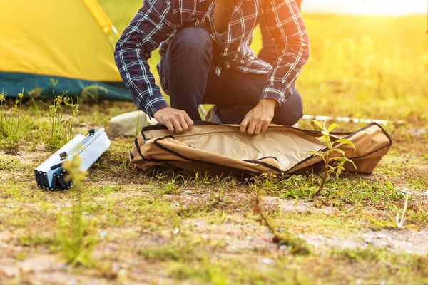 People Pitch a tent on the ground near the lake. Relaxing, traveling, long weeked, holiday concept.