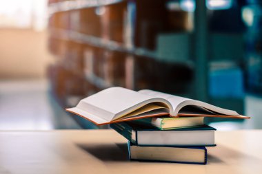 Kütüphanede, okulda, üniversitede, üniversitede kitap yığınları hakkında açık kitap.