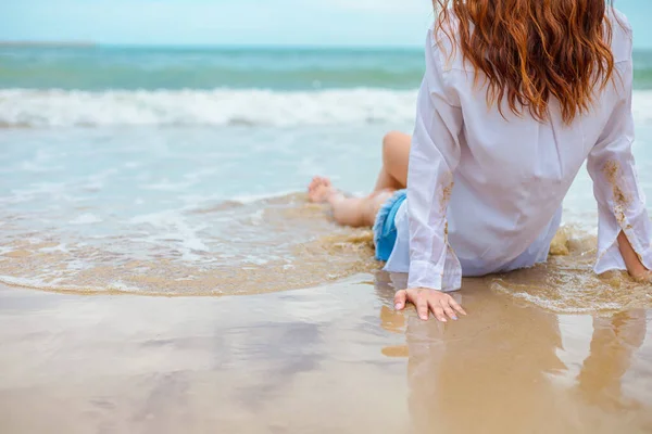 Młoda Kobieta Siedząca Piasku Patrząca Morze Przepływającą Wodę Plaży — Zdjęcie stockowe