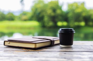 Masanın üzerindeki kitabın yanında küçük bir fincan kahve..