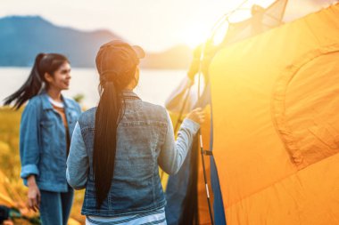 İnsanlar gün batımında göl kenarında çadır kurar. Rahatlatıcı, seyahat, uzun bir hafta, tatil konsepti.