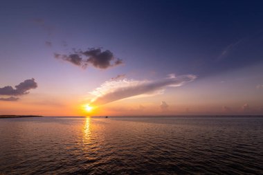 Alacakaranlıkta güzel bulutlarla deniz ve gün batımı. Deniz manzarası arkaplanı.