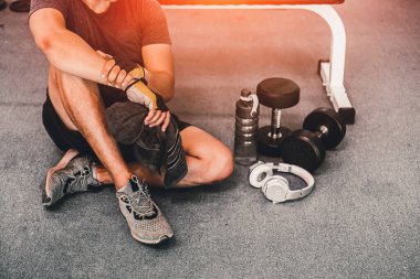 Kaslı, beyaz bir genç spor salonunda iyi bir sağlık için çalıştıktan sonra dinleniyor. spor egzersiz konsepti